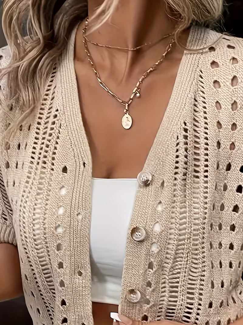 Cardigan beige ajouré à manches courtes, léger et subtil, idéal pour apporter une touche chic et raffinée à vos tenues d’été avec élégance