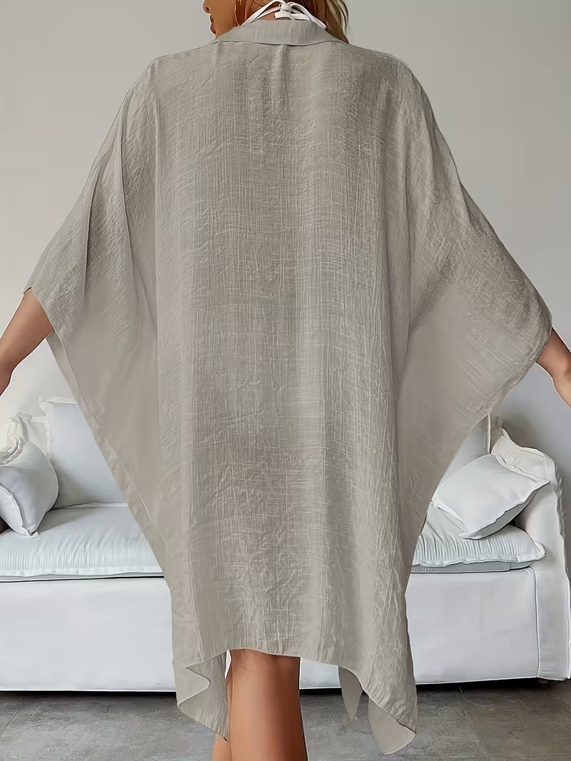 Chemise de plage loose, féminine et subtilement sensuelle, à la coupe fluide qui effleure la silhouette pour un look chic, léger et irrésistiblement estival