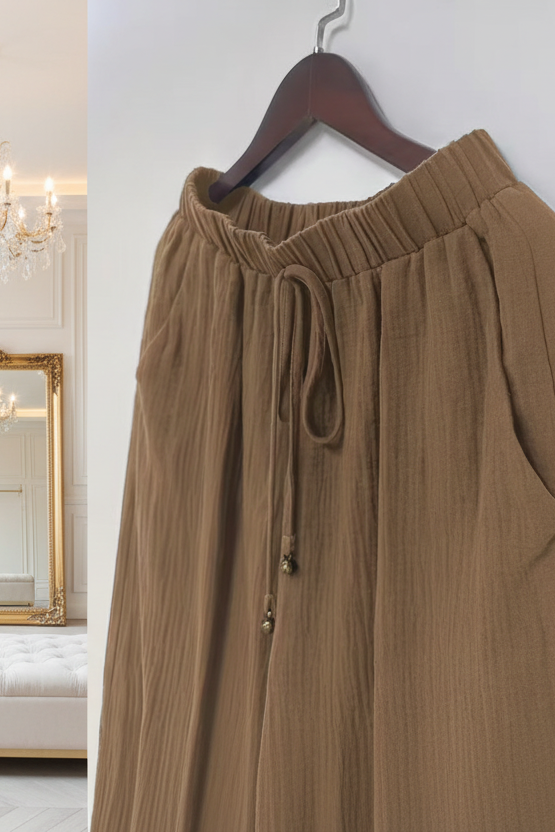 Le pantalon en lin loose qui redéfinit le confort avec style grâce à sa coupe fluide ultra tendance et son design épuré rehaussé d’un cordon qui apporte une touche casual parfaitement maîtrisée