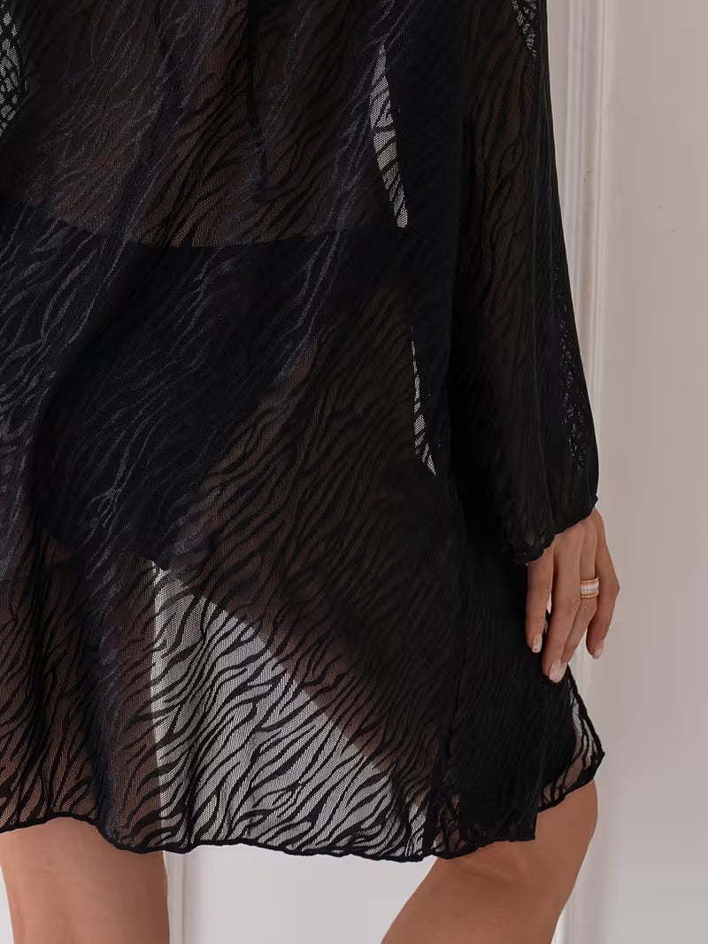 Le cover-up de plage voile avec sa coupe fluide et légèrement dévoilante, il transforme chaque pas en véritable moment de style, du sable chaud au sunset chic