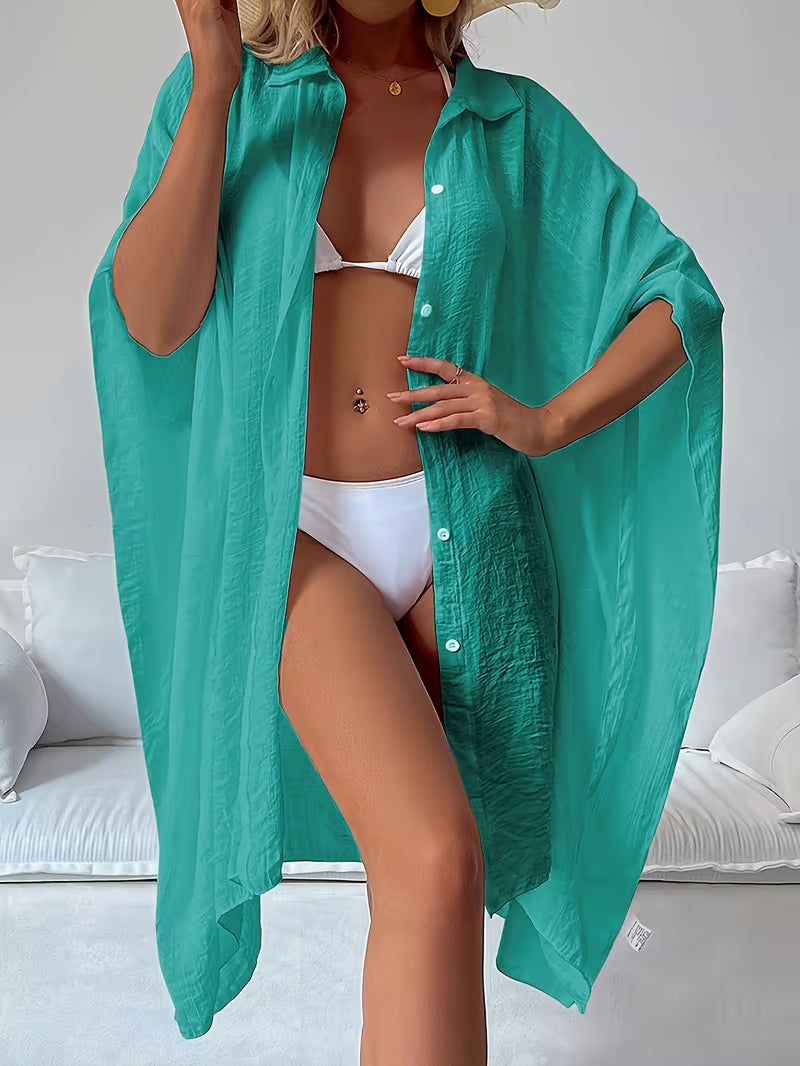 Chemise de plage loose, féminine et subtilement sensuelle, à la coupe fluide qui effleure la silhouette pour un look chic, léger et irrésistiblement estival