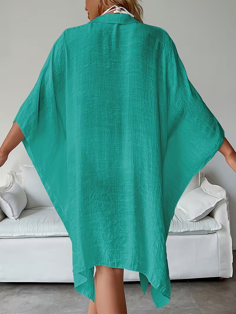 Chemise de plage loose, féminine et subtilement sensuelle, à la coupe fluide qui effleure la silhouette pour un look chic, léger et irrésistiblement estival