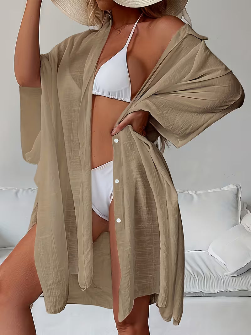 Chemise de plage loose, féminine et subtilement sensuelle, à la coupe fluide qui effleure la silhouette pour un look chic, léger et irrésistiblement estival