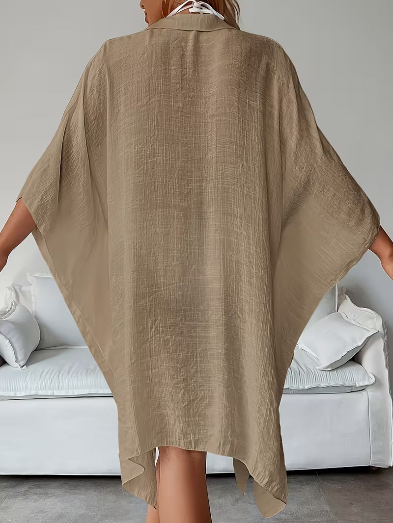 Chemise de plage loose, féminine et subtilement sensuelle, à la coupe fluide qui effleure la silhouette pour un look chic, léger et irrésistiblement estival