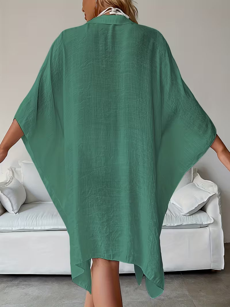Chemise de plage loose, féminine et subtilement sensuelle, à la coupe fluide qui effleure la silhouette pour un look chic, léger et irrésistiblement estival
