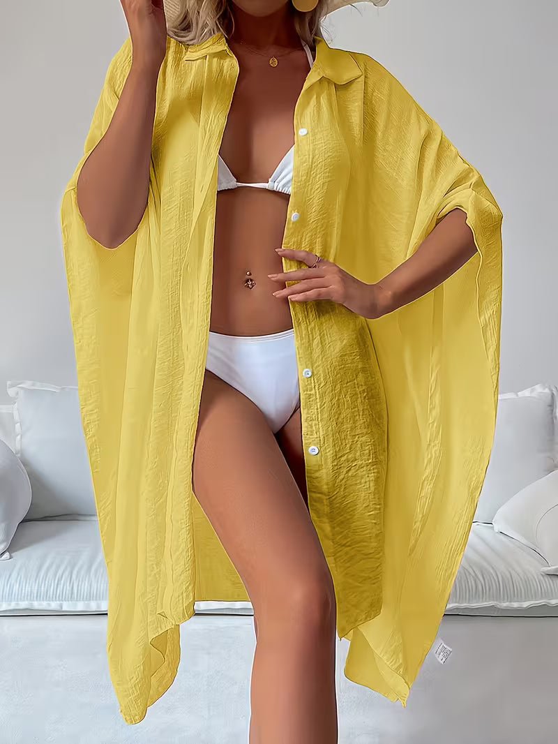 Chemise de plage loose, féminine et subtilement sensuelle, à la coupe fluide qui effleure la silhouette pour un look chic, léger et irrésistiblement estival