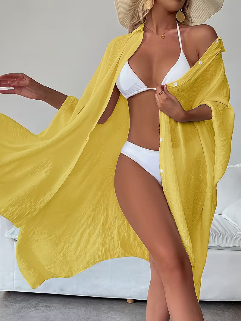 Chemise de plage loose, féminine et subtilement sensuelle, à la coupe fluide qui effleure la silhouette pour un look chic, léger et irrésistiblement estival