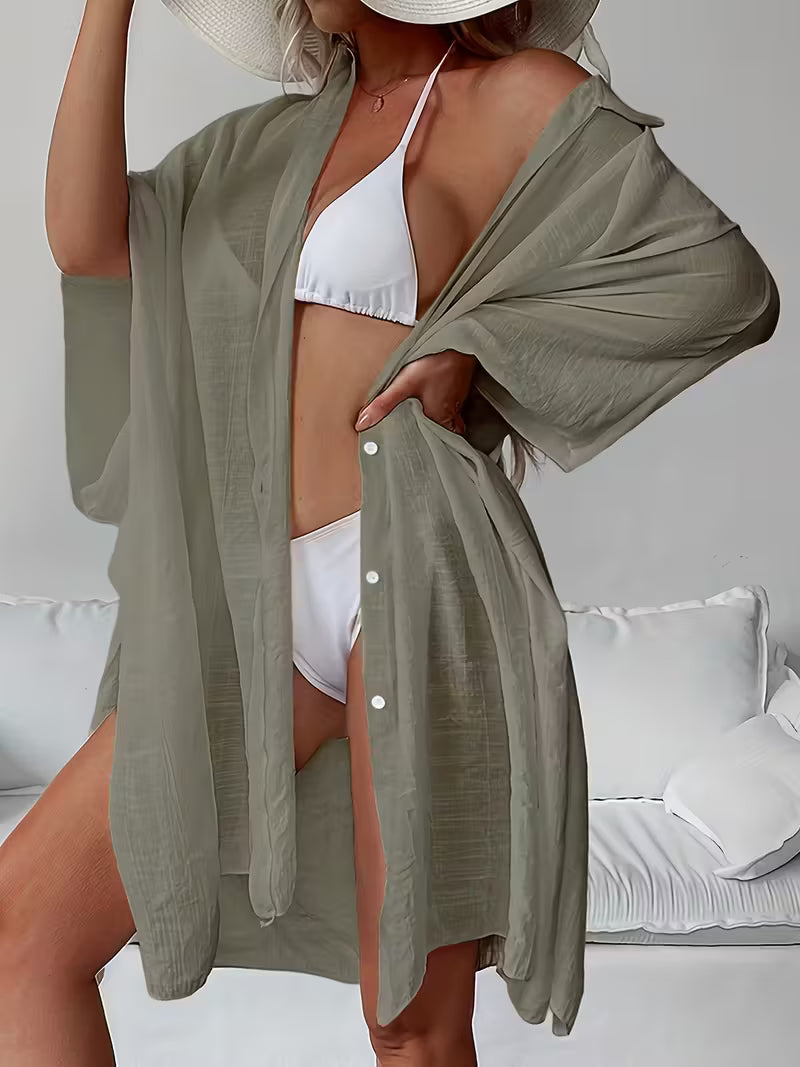 Chemise de plage loose, féminine et subtilement sensuelle, à la coupe fluide qui effleure la silhouette pour un look chic, léger et irrésistiblement estival