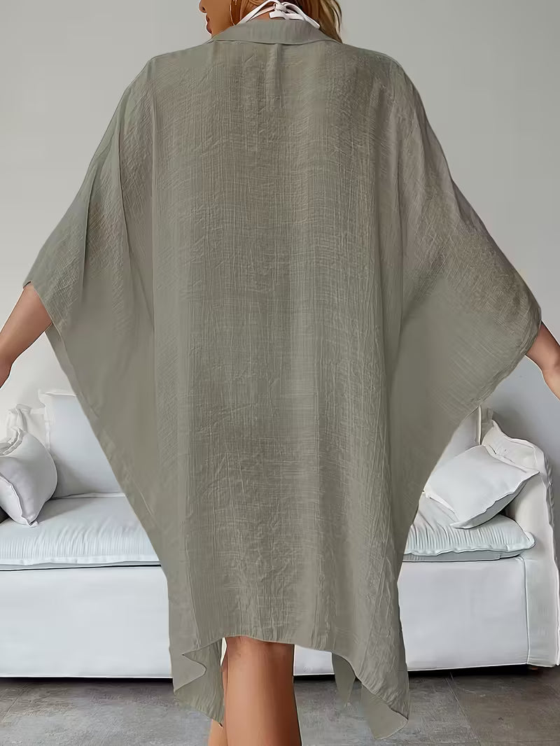 Chemise de plage loose, féminine et subtilement sensuelle, à la coupe fluide qui effleure la silhouette pour un look chic, léger et irrésistiblement estival