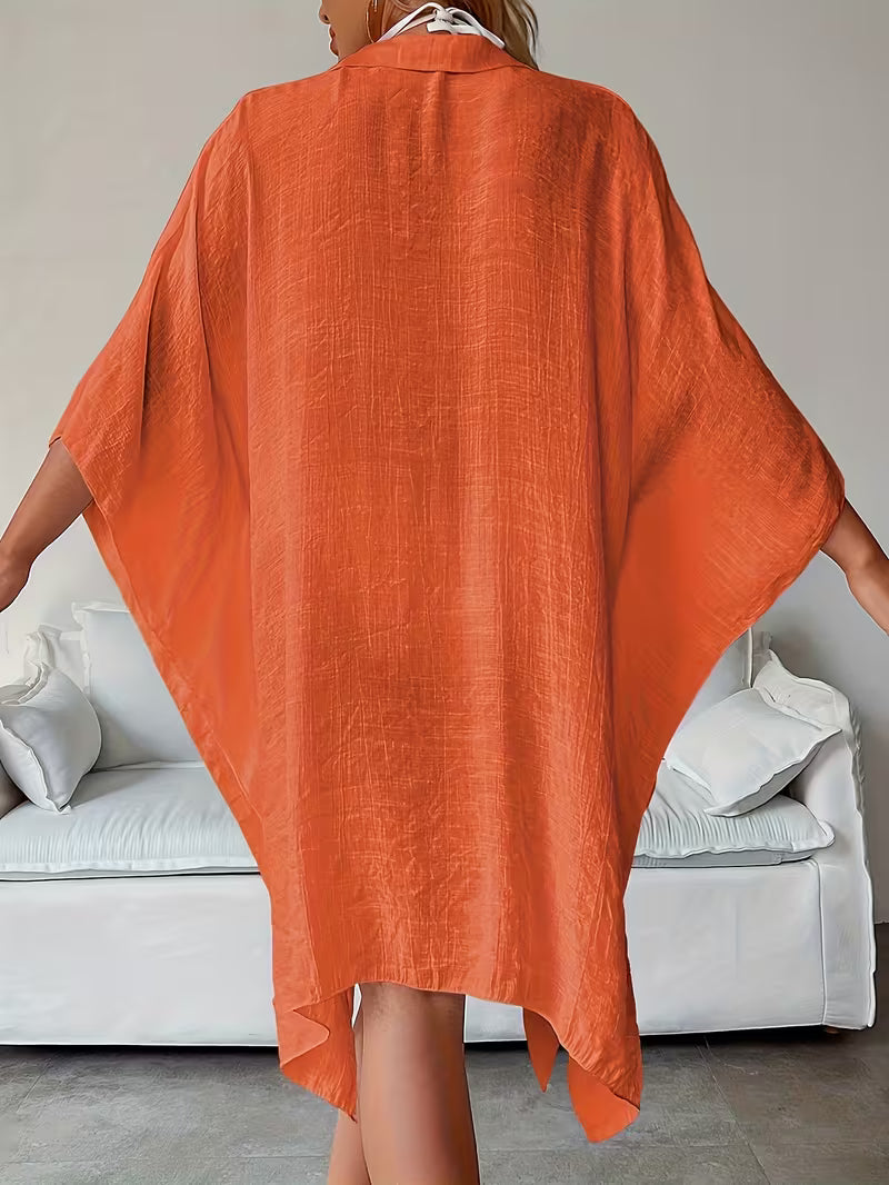 Chemise de plage loose, féminine et subtilement sensuelle, à la coupe fluide qui effleure la silhouette pour un look chic, léger et irrésistiblement estival