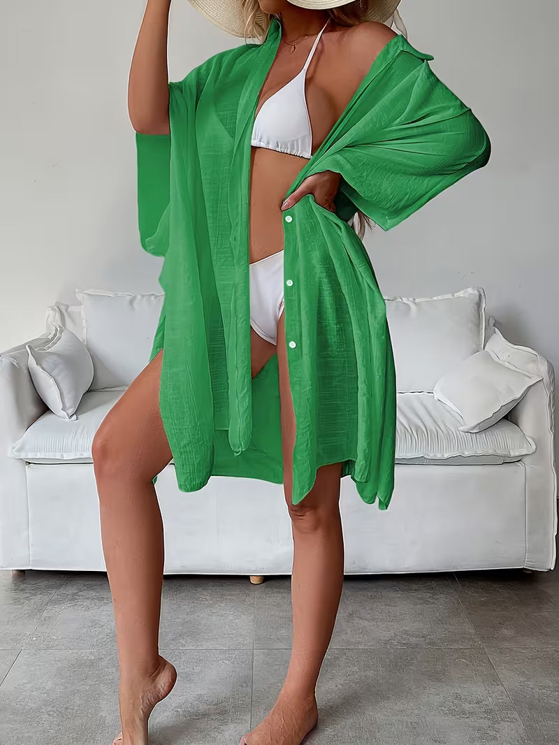 Chemise de plage loose, féminine et subtilement sensuelle, à la coupe fluide qui effleure la silhouette pour un look chic, léger et irrésistiblement estival